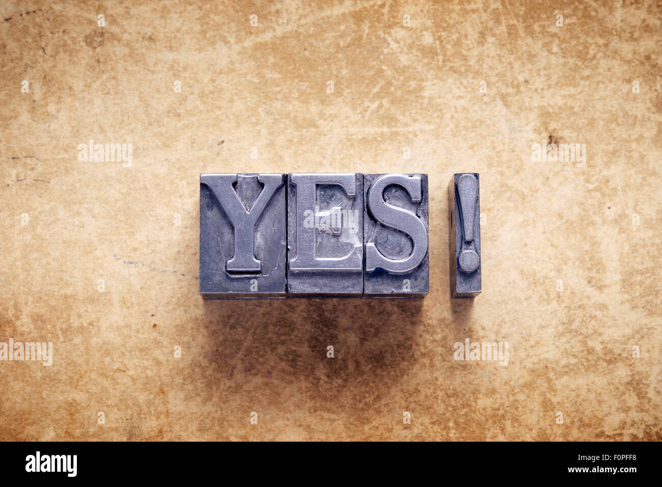 yes exclamation made from metallic letterpress type on vintage cardboard Stock Photo