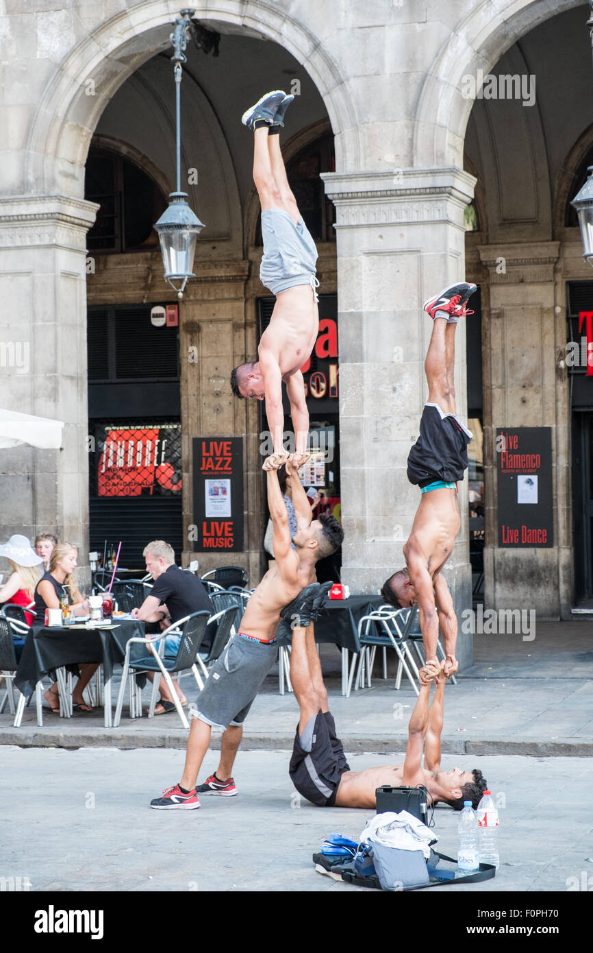 Street performers, acrobats perform in front of a cafe in Placa Reial,Plaza Real,just off La Rambla,Barcelona,Spain. Stock Photo