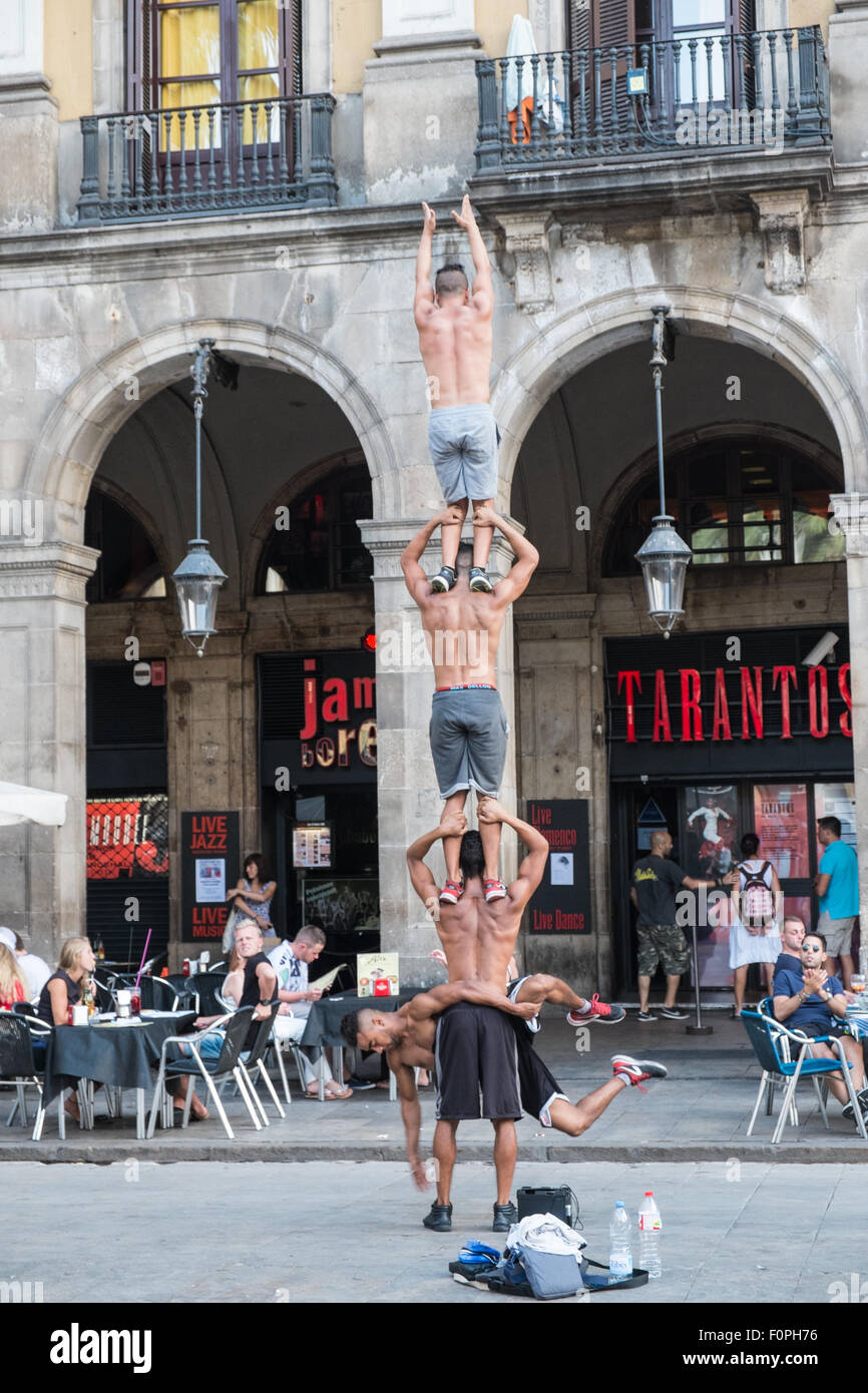 Street performers, acrobats perform in front of a cafe in Placa Reial,Plaza Real,just off La Rambla,Barcelona,Spain. Stock Photo