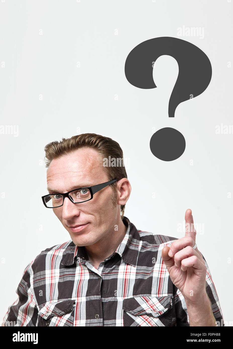 Handsome man in eyeglasses and tartan shirt put his index finger up and show for question mark. Question concept Stock Photo