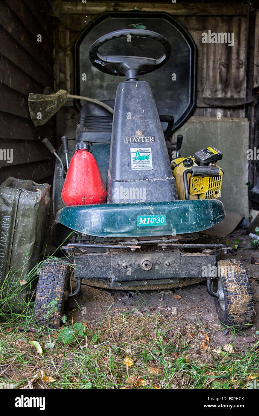 Ride on mower stored in a wooden shed Stock Photo