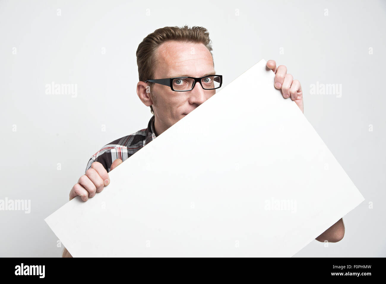 man in eyeglasses peep from the white board. . Stock Photo