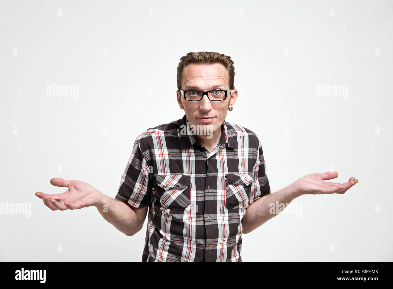 Man in casual clothes shrug his hands in amazement Stock Photo