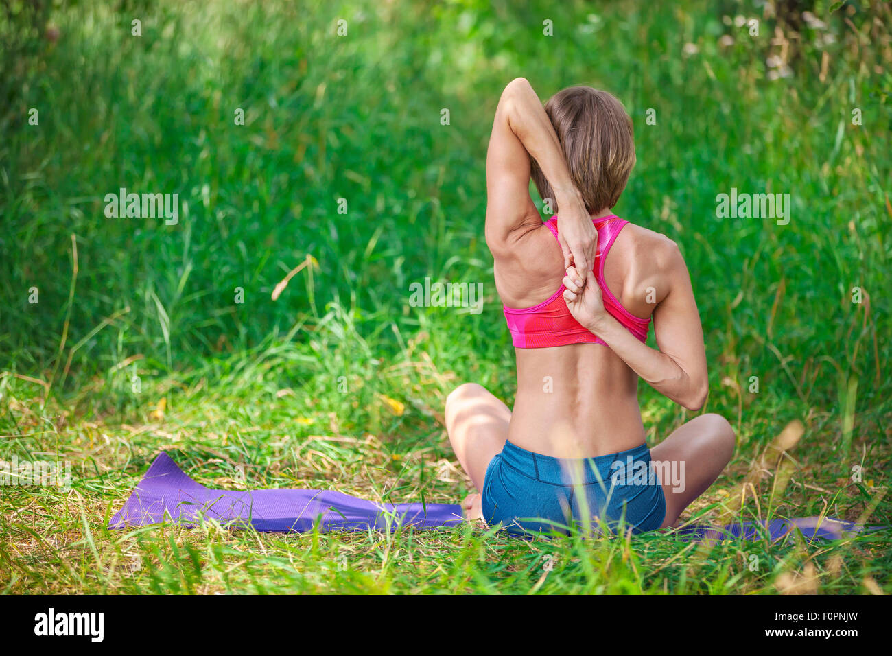 Young Caucasian woman sitting and stretching her arms behind her back Stock Photo