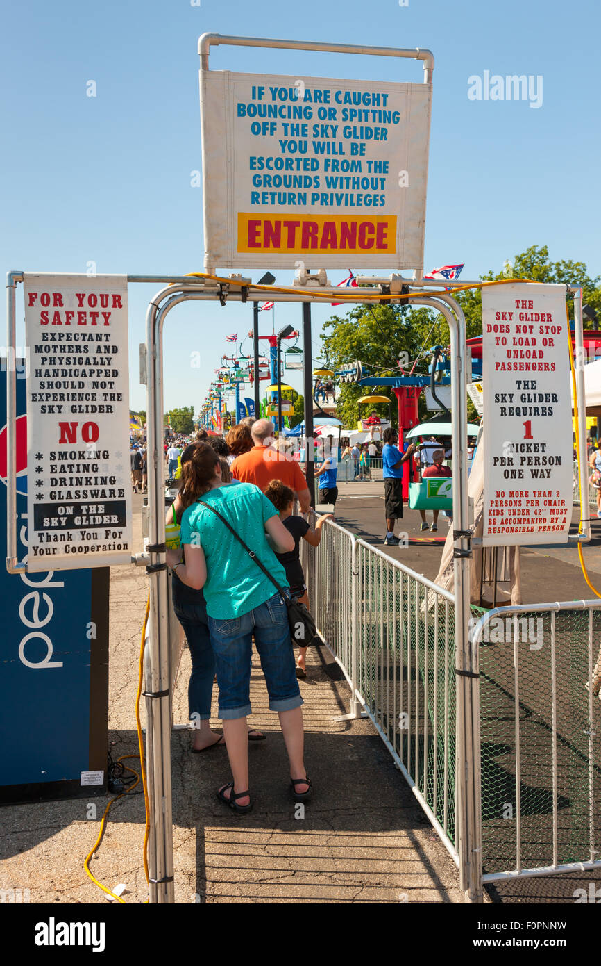Rules and warnings are posted as people enter the line for the Sky Glider at the Ohio State Fair in Columbus, Ohio. Stock Photo