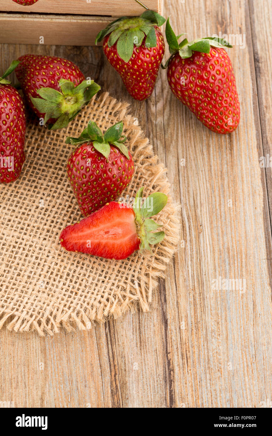 Strawberries over odl brown wooden table background Stock Photo - Alamy
