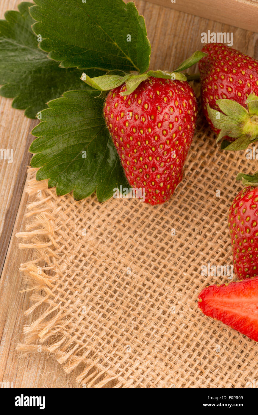 Strawberries over odl brown wooden table background Stock Photo - Alamy