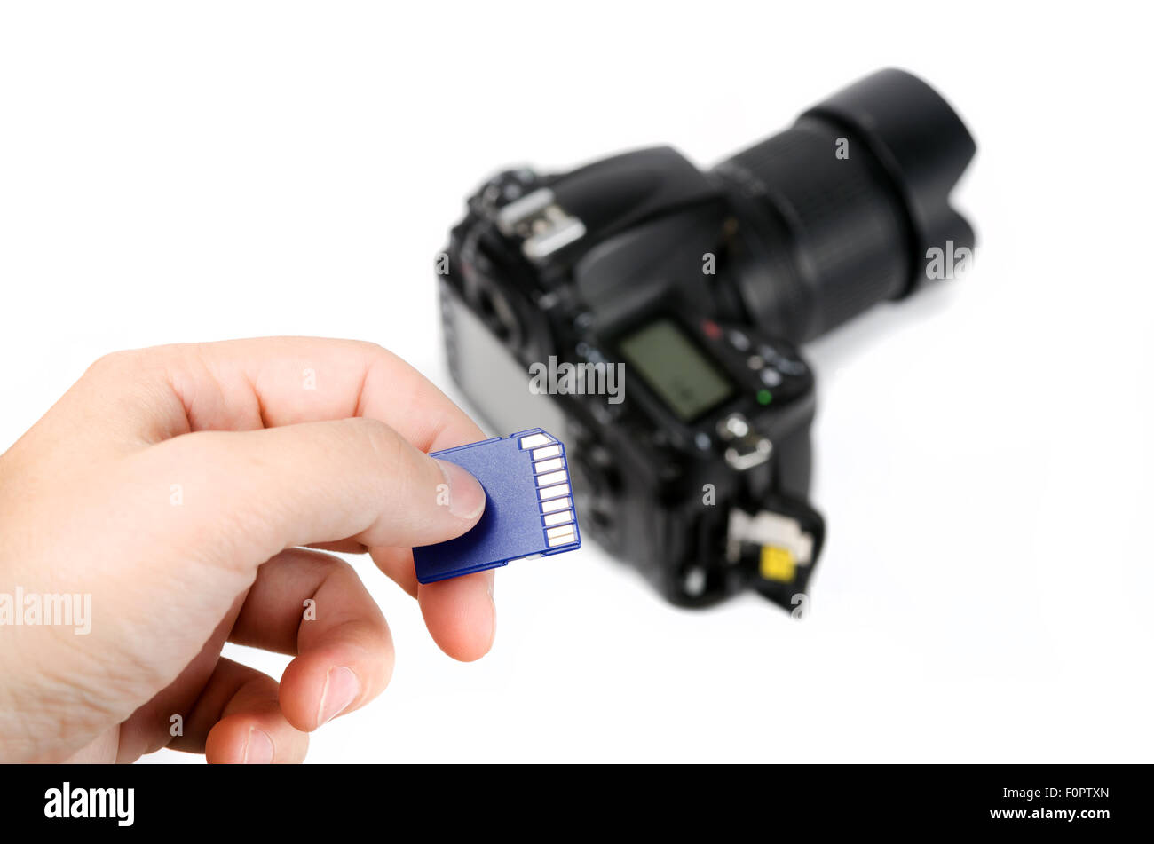 Hand holds SD Memory card - Flash card and DSLR camera on the ...