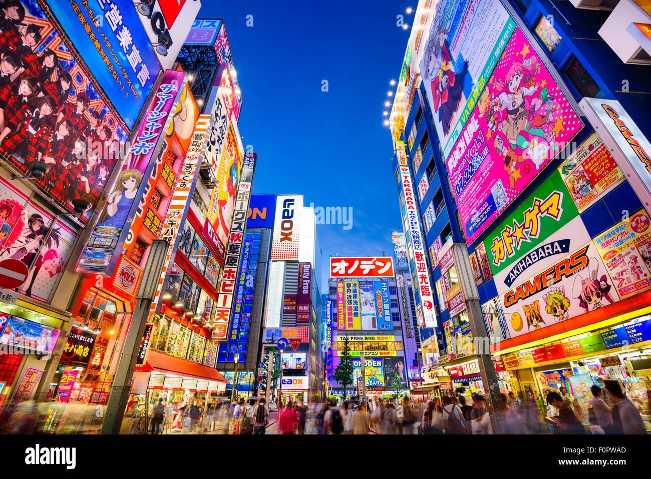 Crowds pass below colorful signs in Akihabara, Tokyo, Japan. Stock Photo