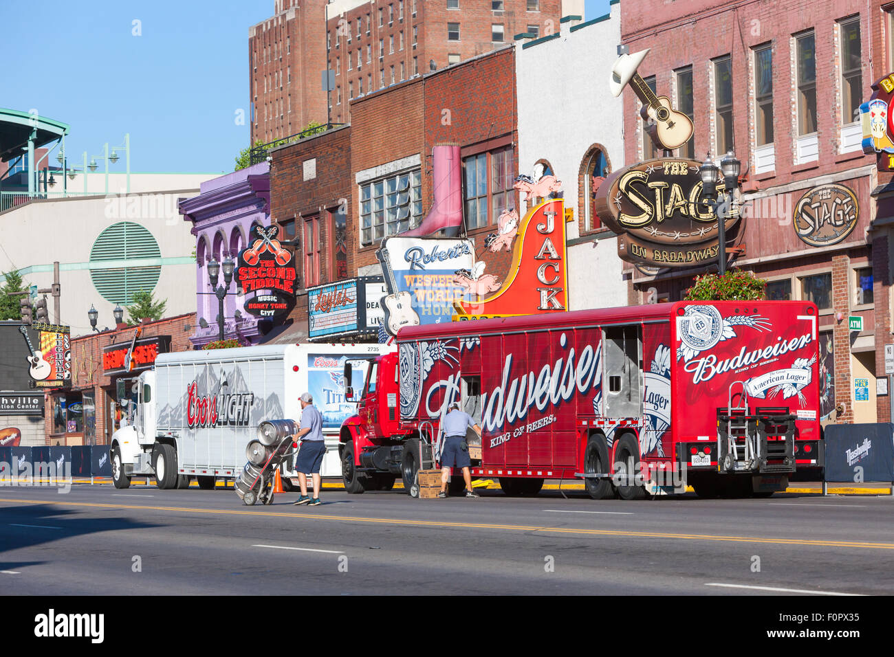 Two delivery men unload kegs of beer from a Budweiser beverage truck in