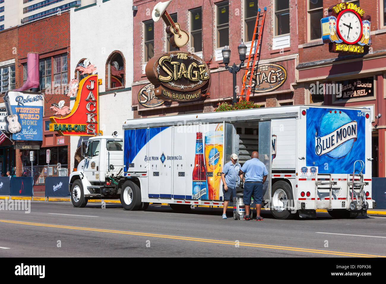 Two delivery men unload beer from a Blue Moon Brewing Company beverage