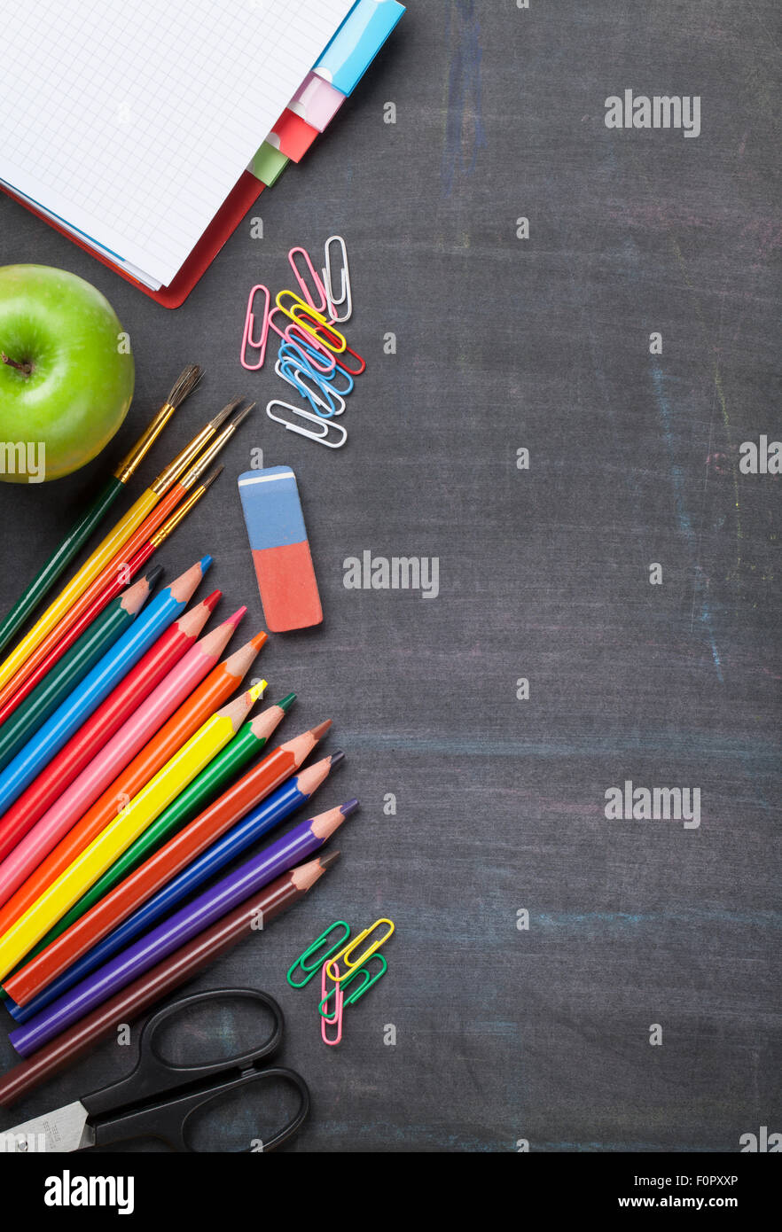 School and office supplies on blackboard background. Top view with copy space Stock Photo