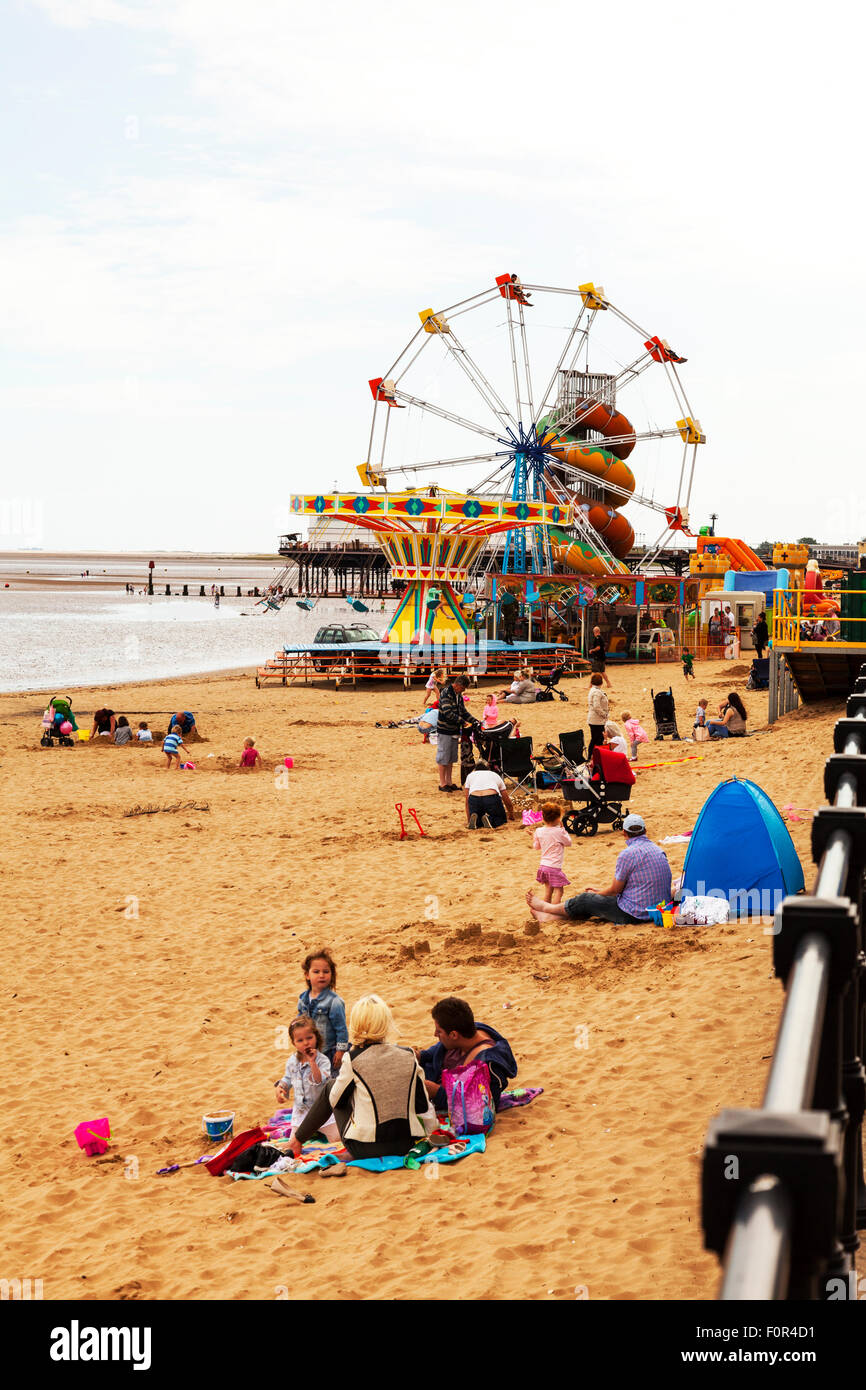 Cleethorpes seafront beach kids playing in sand in front of amusements UK town towns England coast coastal sea Stock Photo