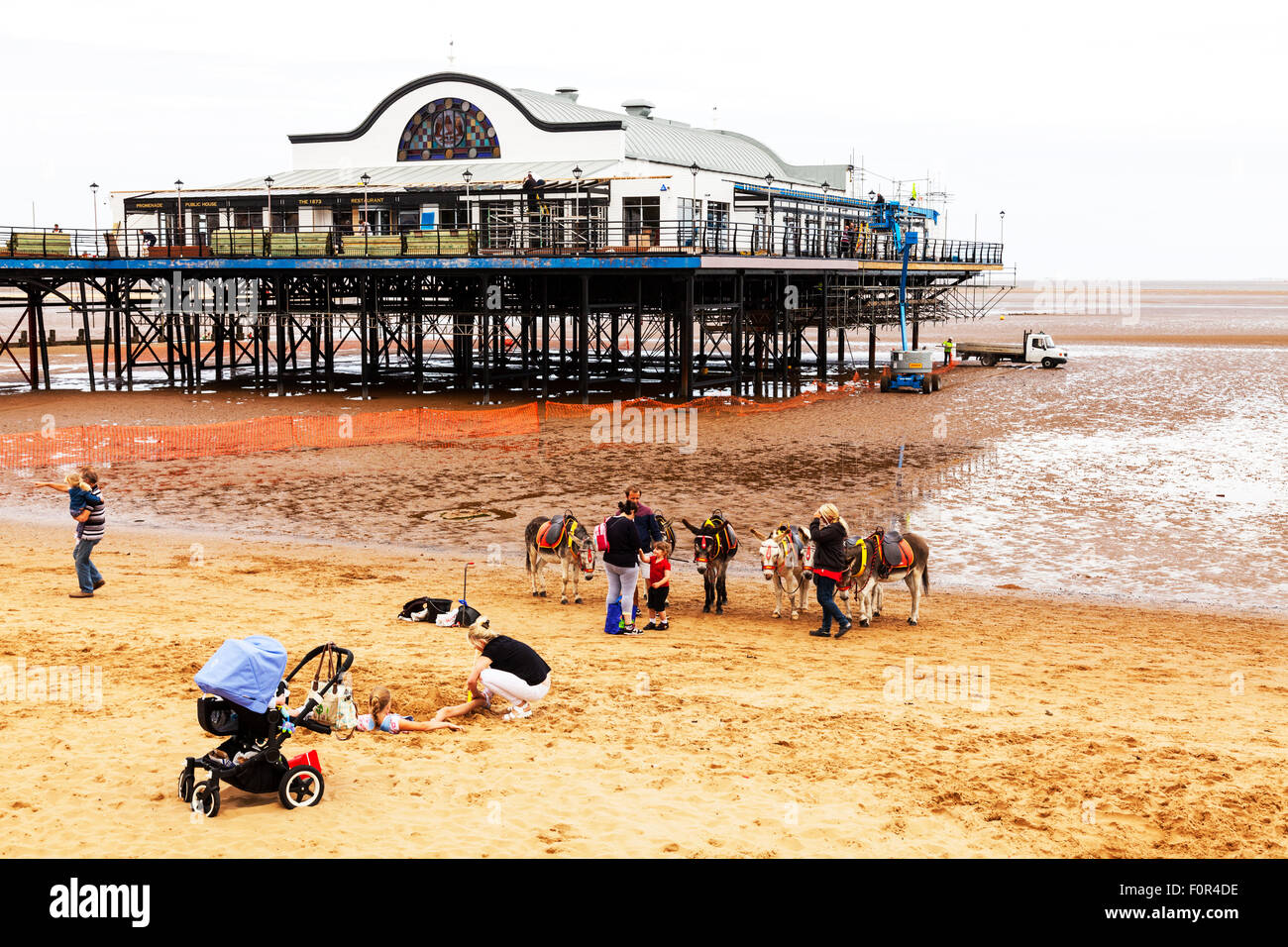 Cleethorpes pier Donkey ride rides on beach child sat on riding donkeys summer entertainment for