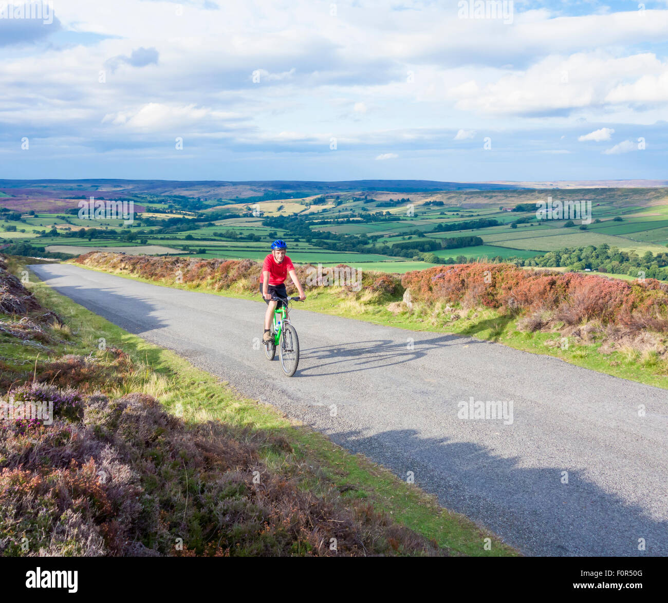 Mountain biker on long, steep climb out of Westerdale, North York Moors National Park, North Yorkshire, England. UK Stock Photo