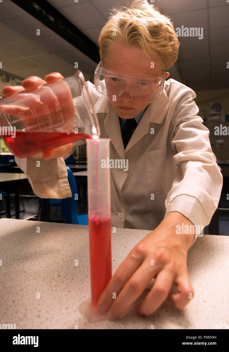 Secondary school pupil undertaking a science experiment in the laboratory, Surrey, UK. Stock Photo