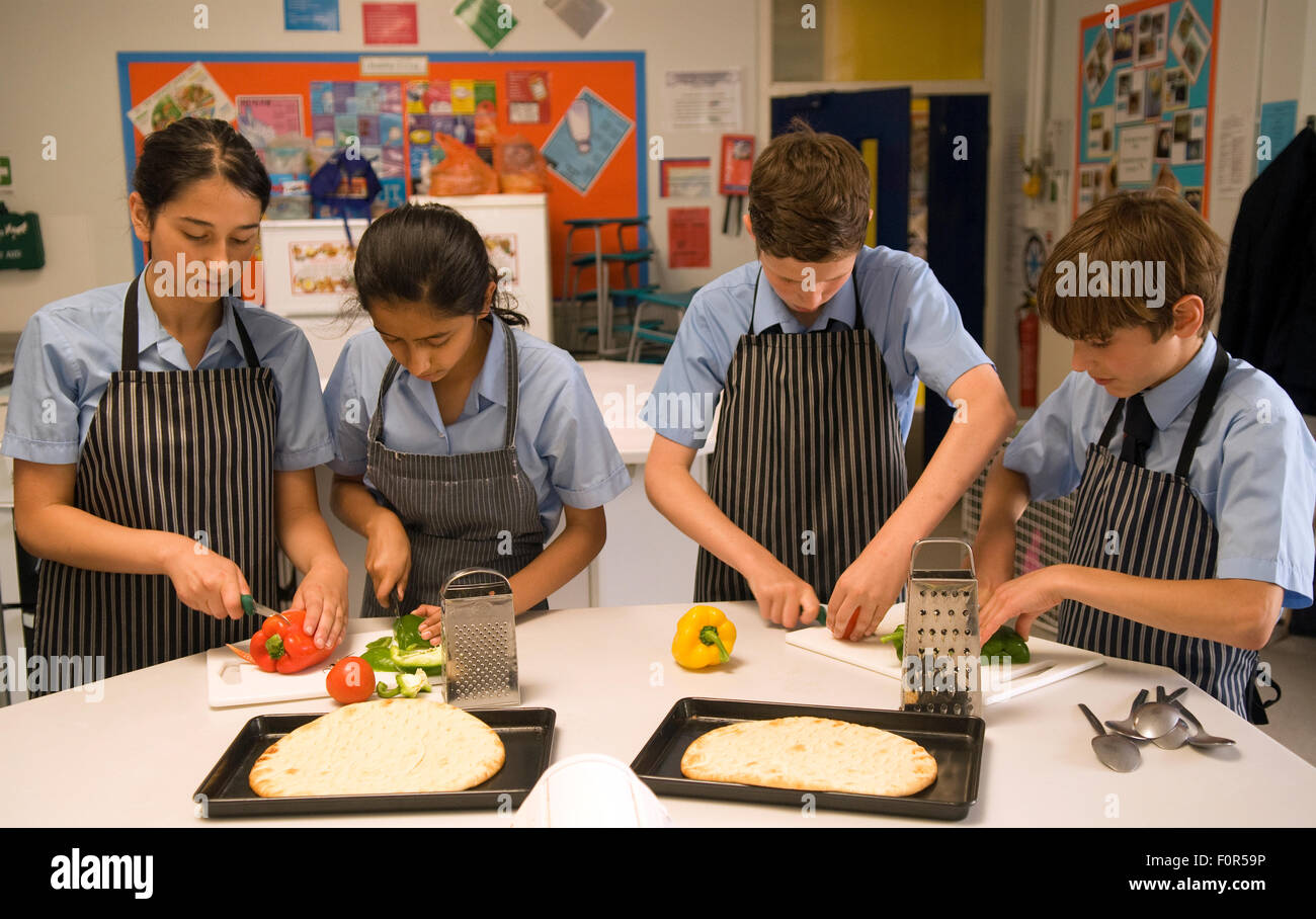 Secondary school pupil's preparing healthy ingredients for a pizza in a cookery lesson, Surrey, UK. Stock Photo