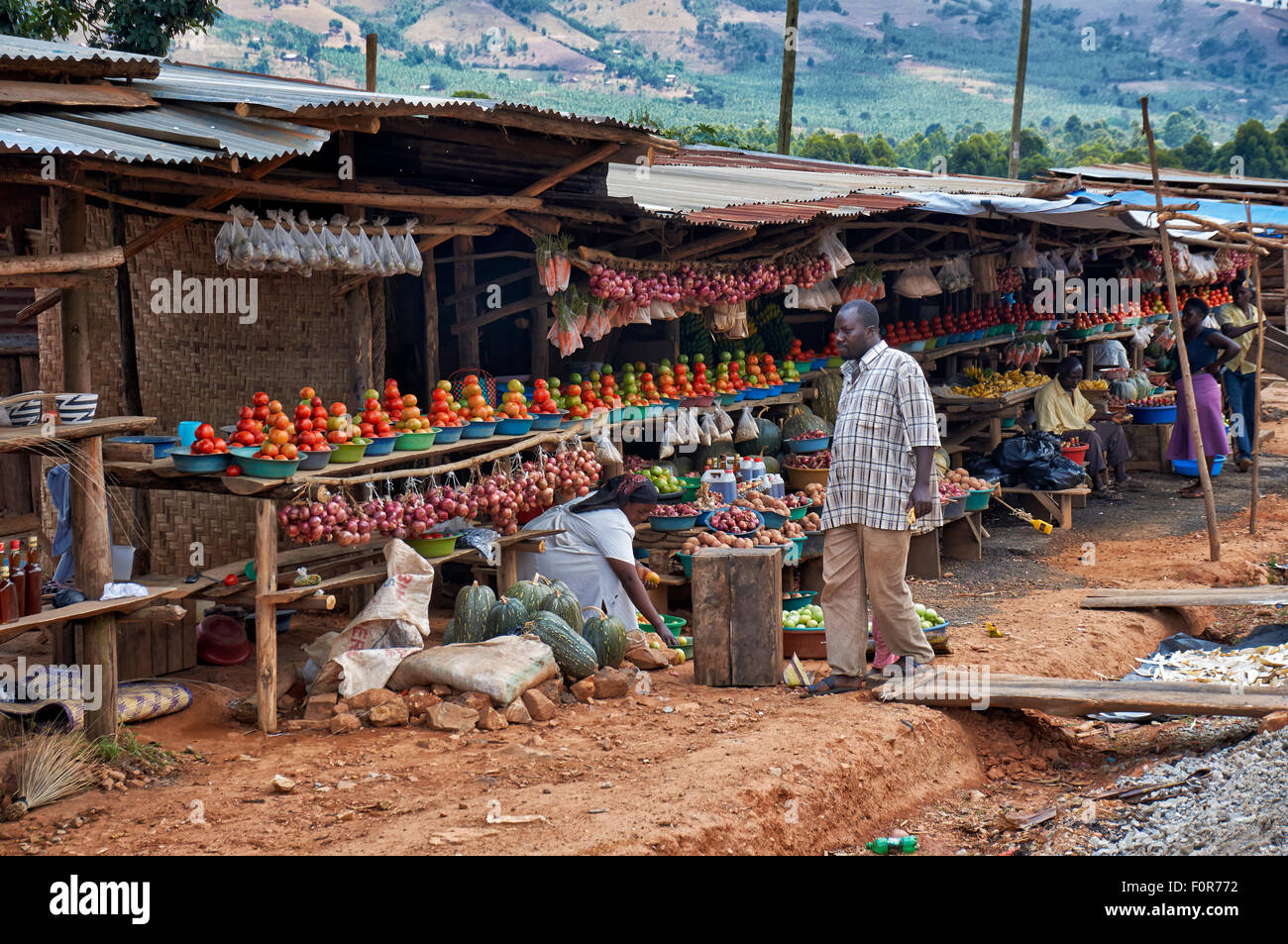 market stalls with fruits and vegetables beneath the road, Uganda