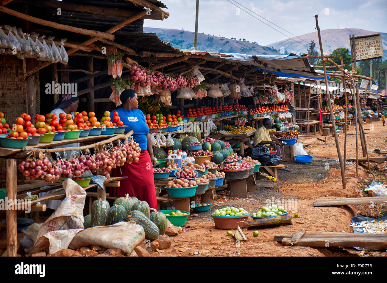 market stalls with fruits and vegetables beneath the road, Uganda
