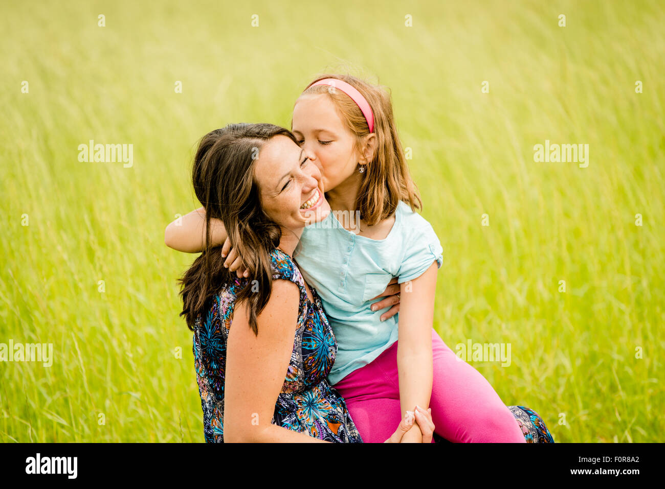 Mother and child are hugging and having fun outdoor in nature Stock Photo