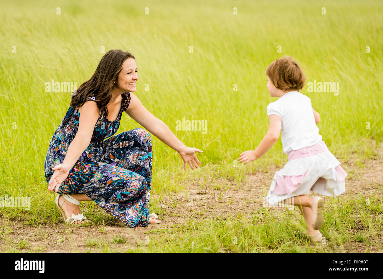 Child running to mother who is waiting with open arms Stock Photo