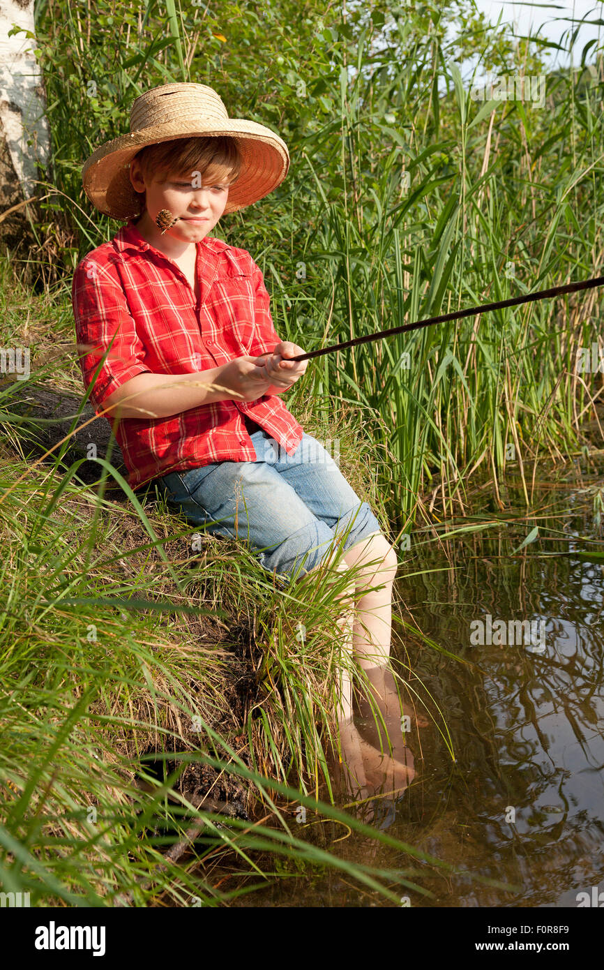 young boy dressed up as Huckleberry Finn fishing Stock Photo - Alamy
