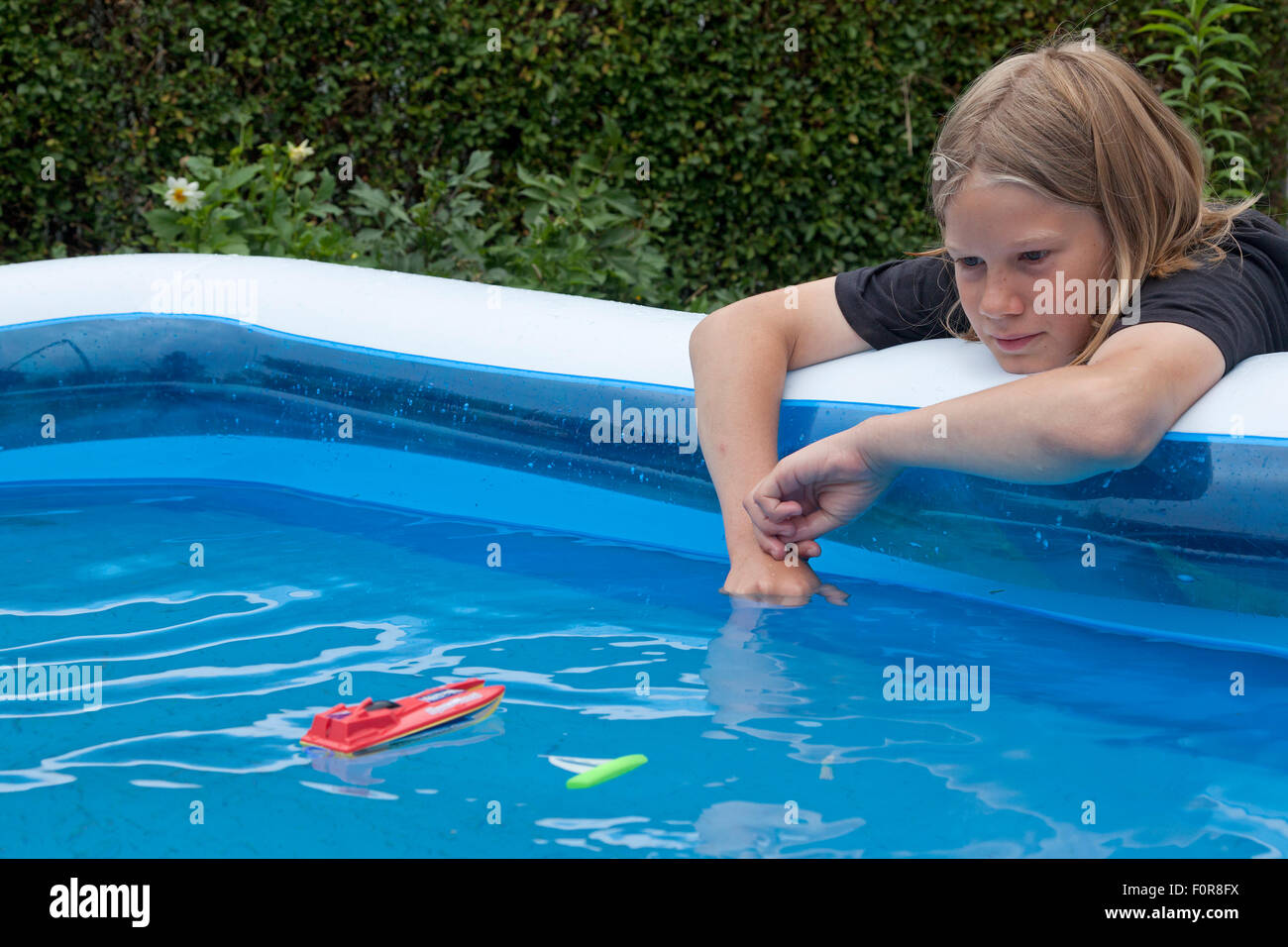 young boy playing with toy boats Stock Photo