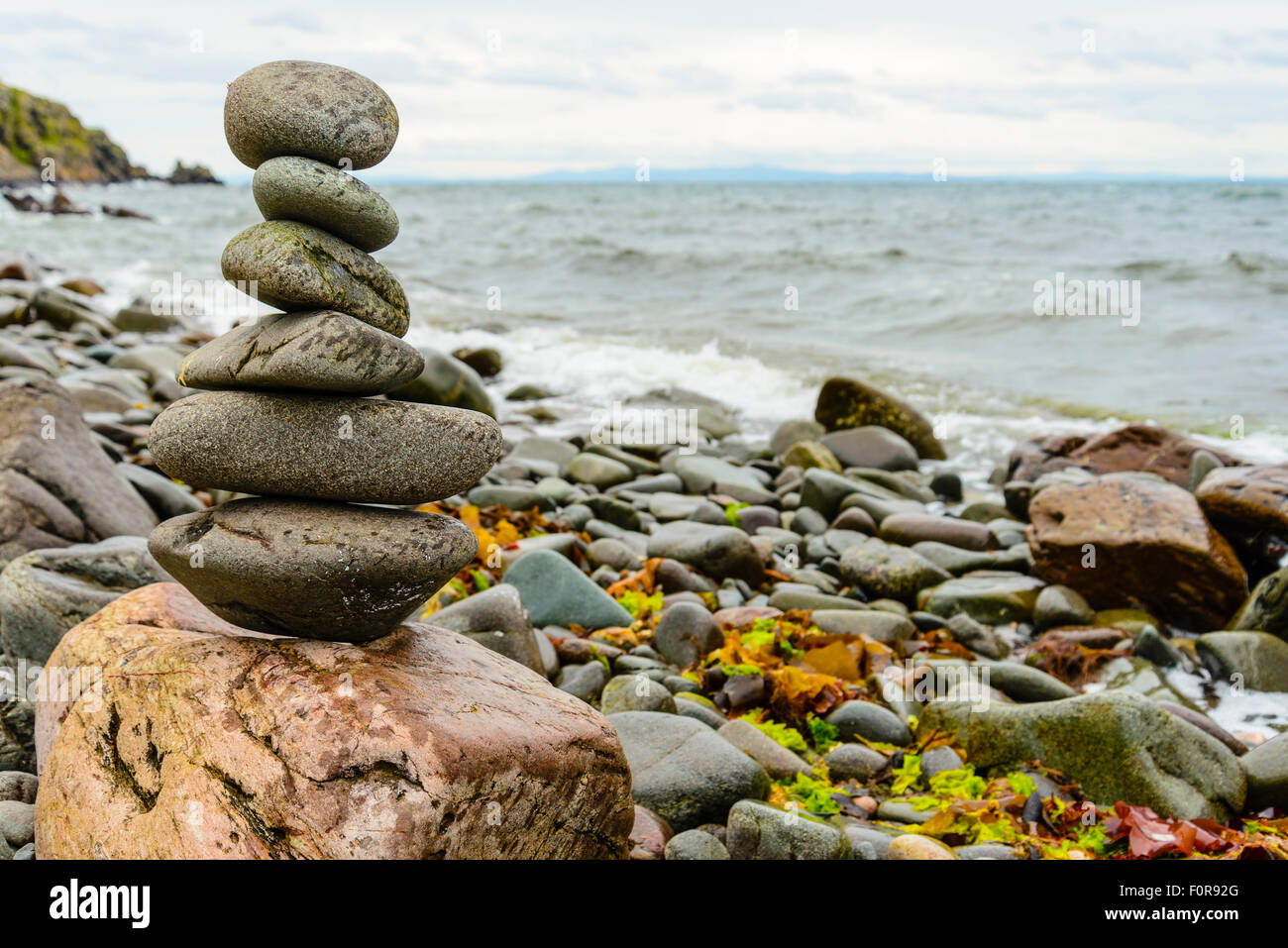 Balanced stones on boulder at Claggain Bay on the island of Islay Scotland Stock Photo