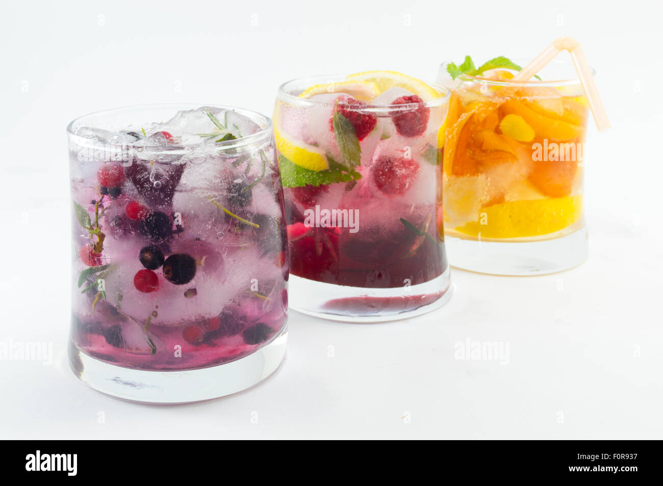 Three non alcoholic fruit cocktails with iced and sliced fruit on white background. Cold summer beverage Stock Photo