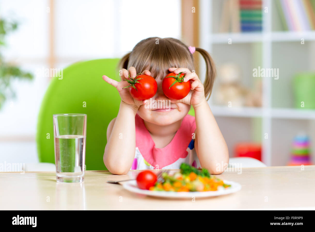 little girl playing with vegetables Stock Photo
