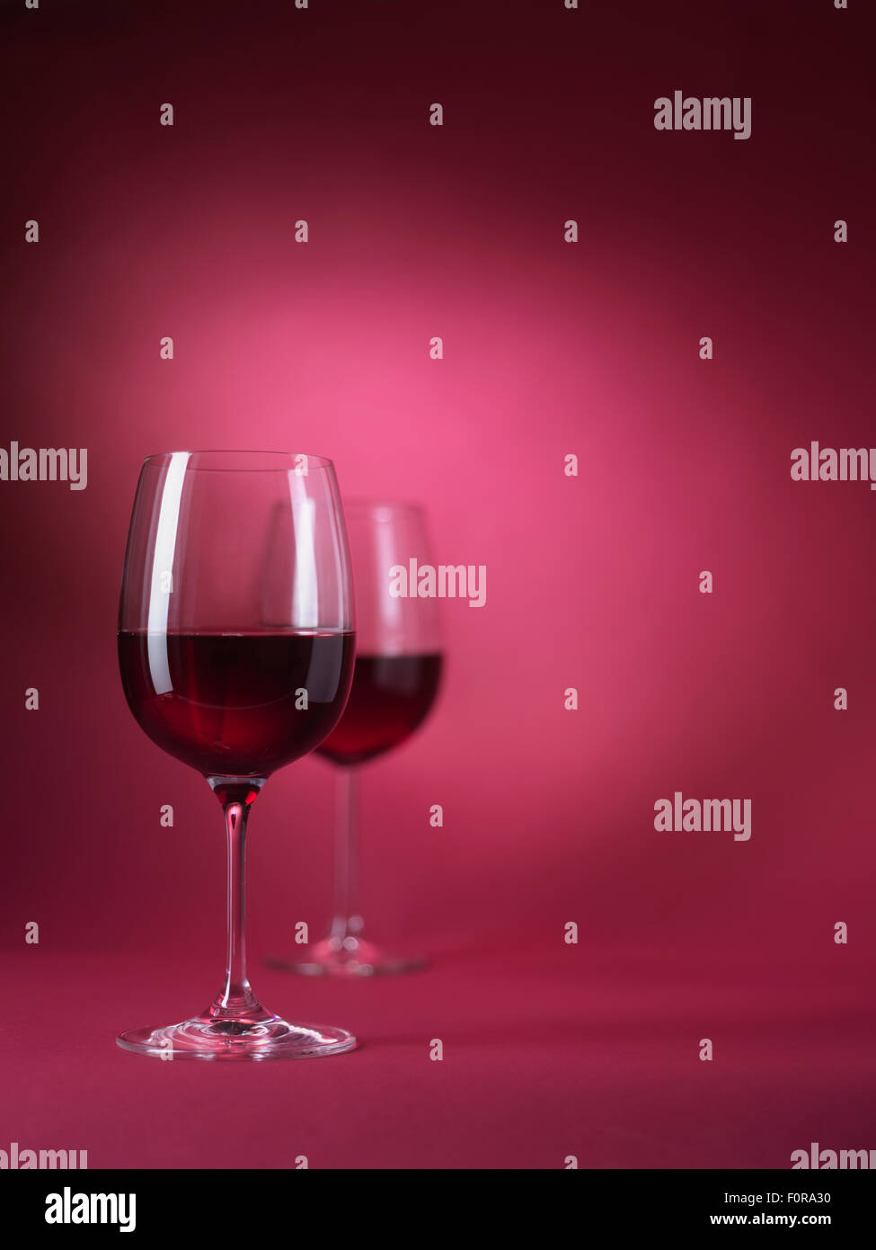 2 red wine glasses on red background Stock Photo