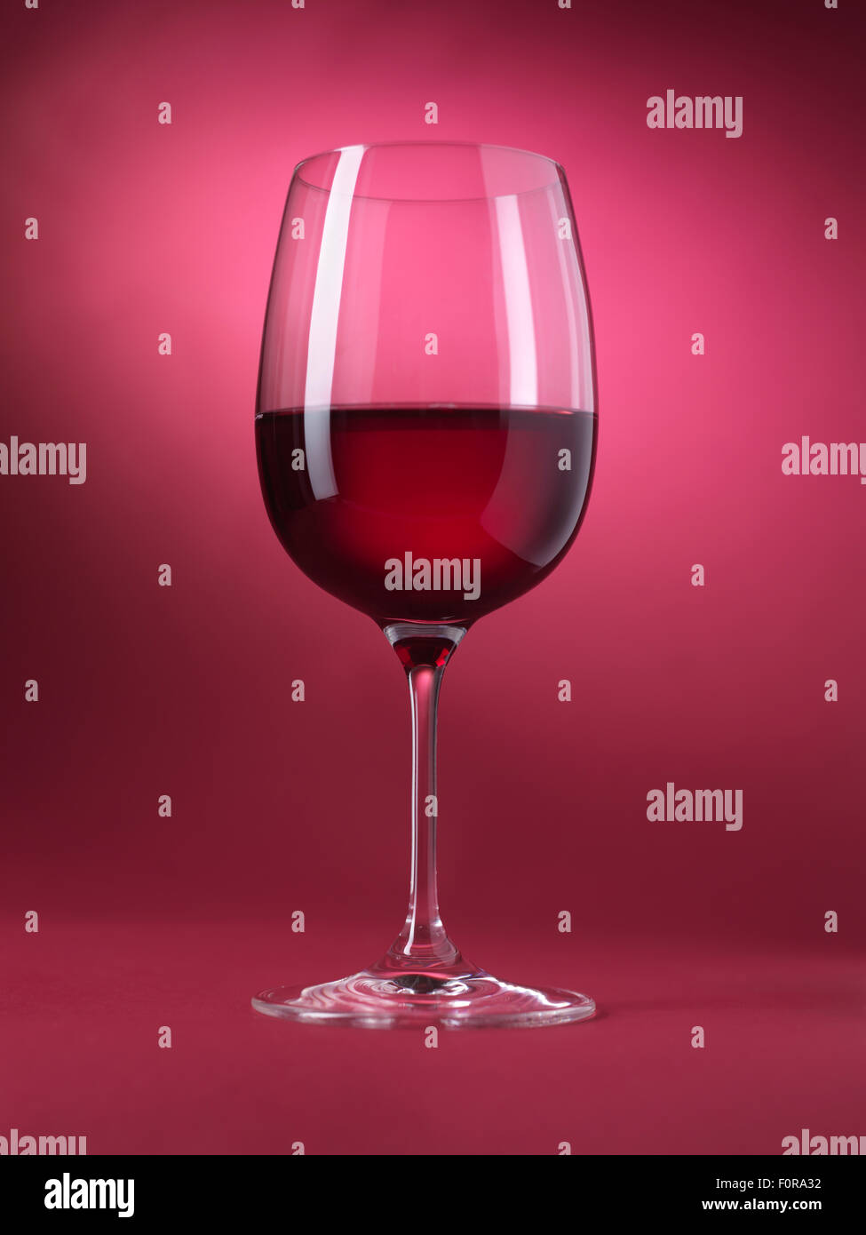 Red wine glass isolated on red background Stock Photo