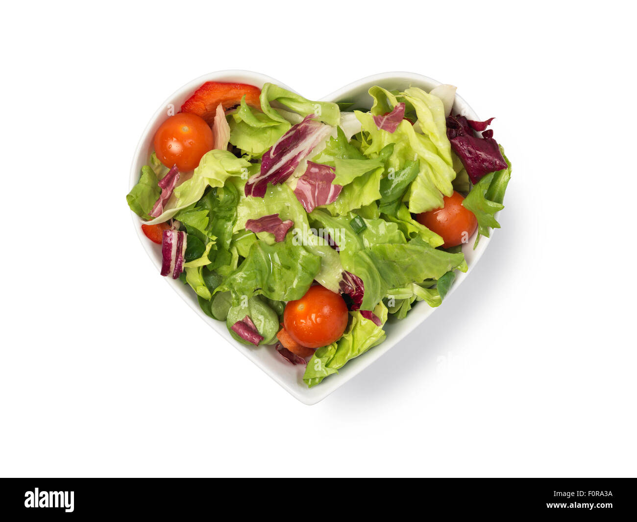 Fresh salad in heart shaped bowl isolated on white with clipping path Stock Photo