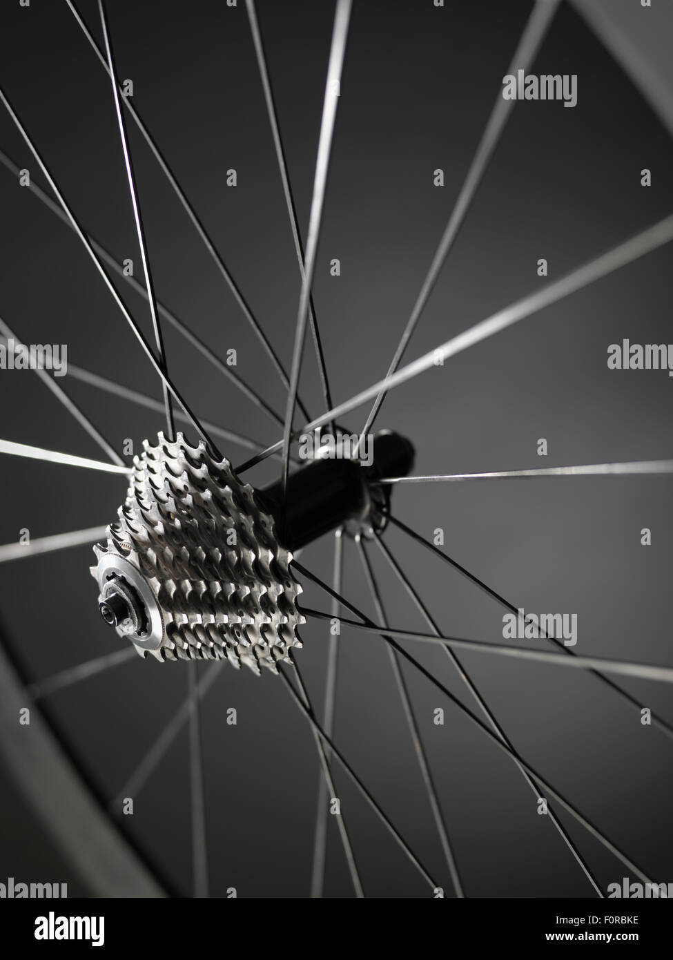 close up shot of bicycle wheel showing gears or cogs with a shallow depth of field showing spokes and rim. The shot has bee take Stock Photo
