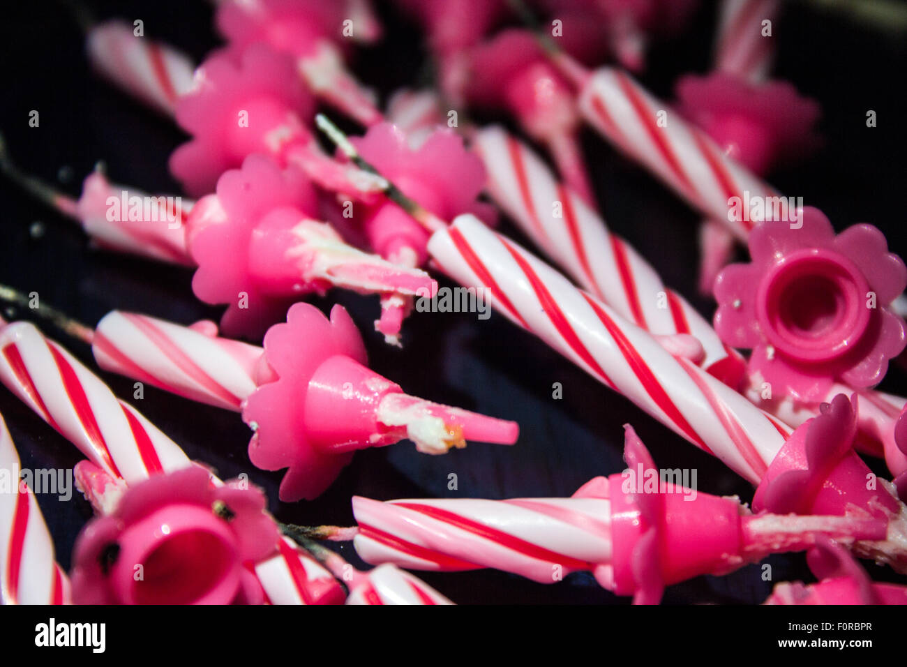 Candles after being blown out and taken off a cake on a plate or dark