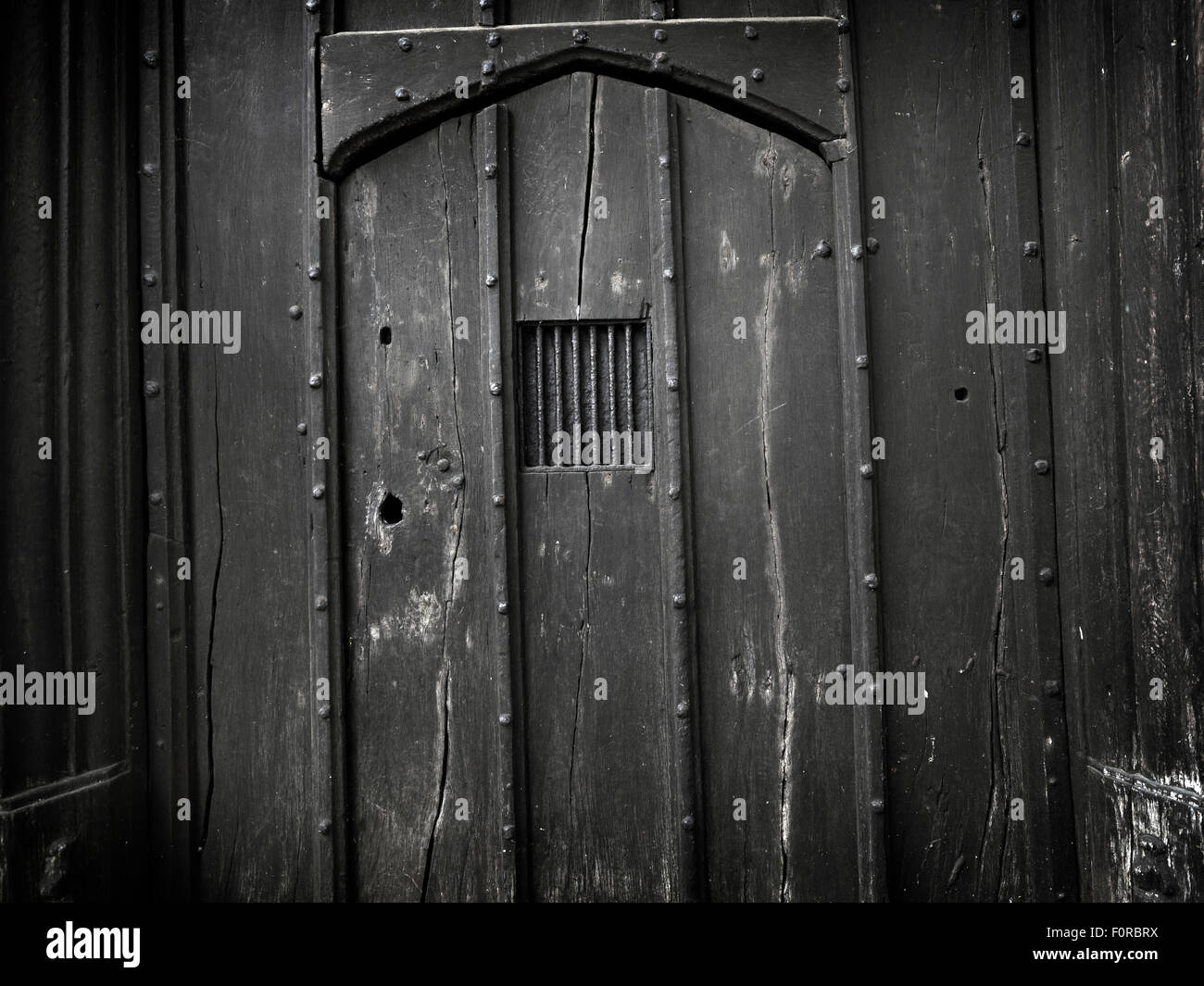 Shoot of a very old, gothic, wooden door ideal for use as a background that is dark and spooky. Many imperfections have been lef Stock Photo