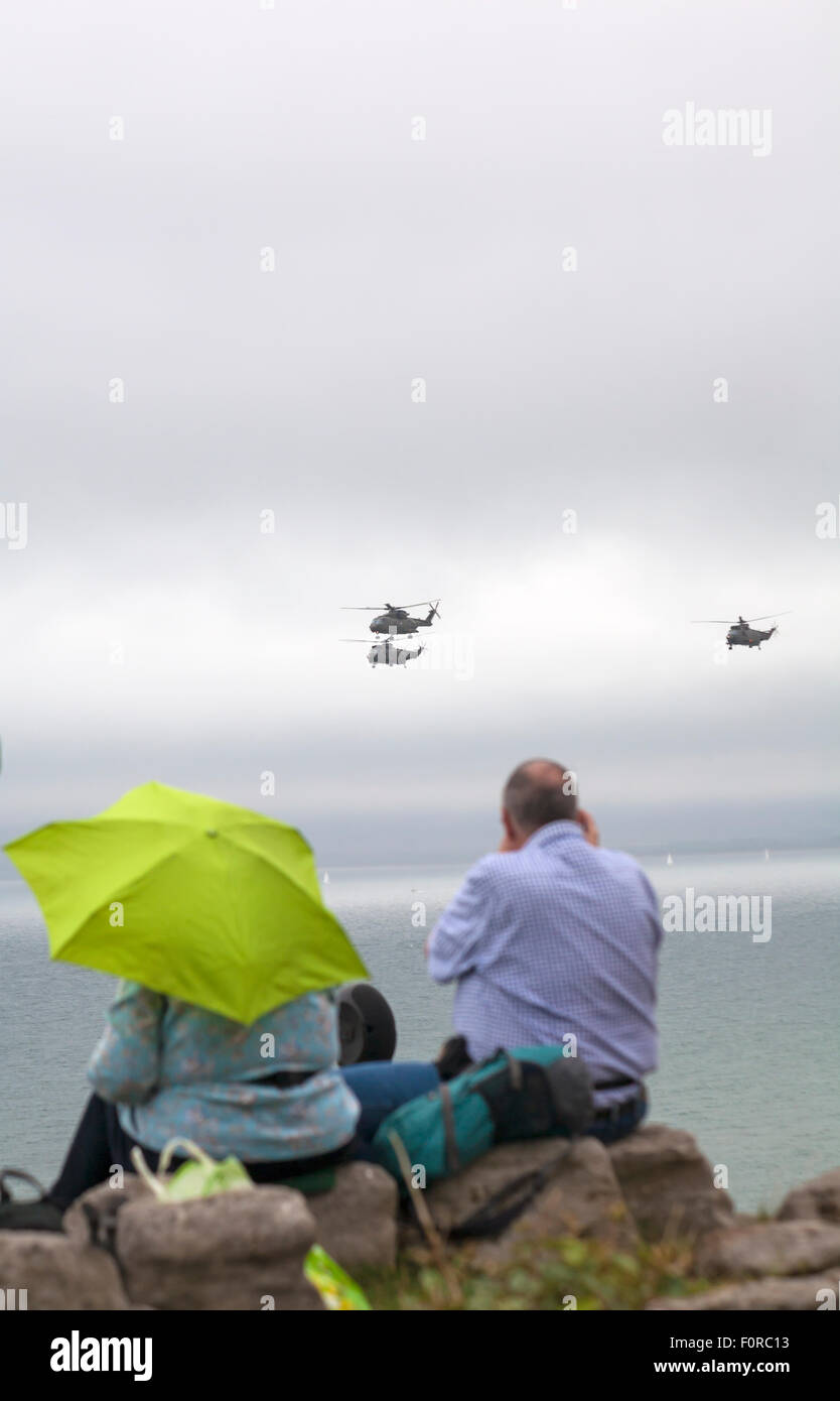 Bournemouth, UK. 20 August 2015. Merlin helicopters perform at the Bournemouth Air Festival - spectators shelter under umbrellas in the rain Credit:  Carolyn Jenkins/Alamy Live News Stock Photo