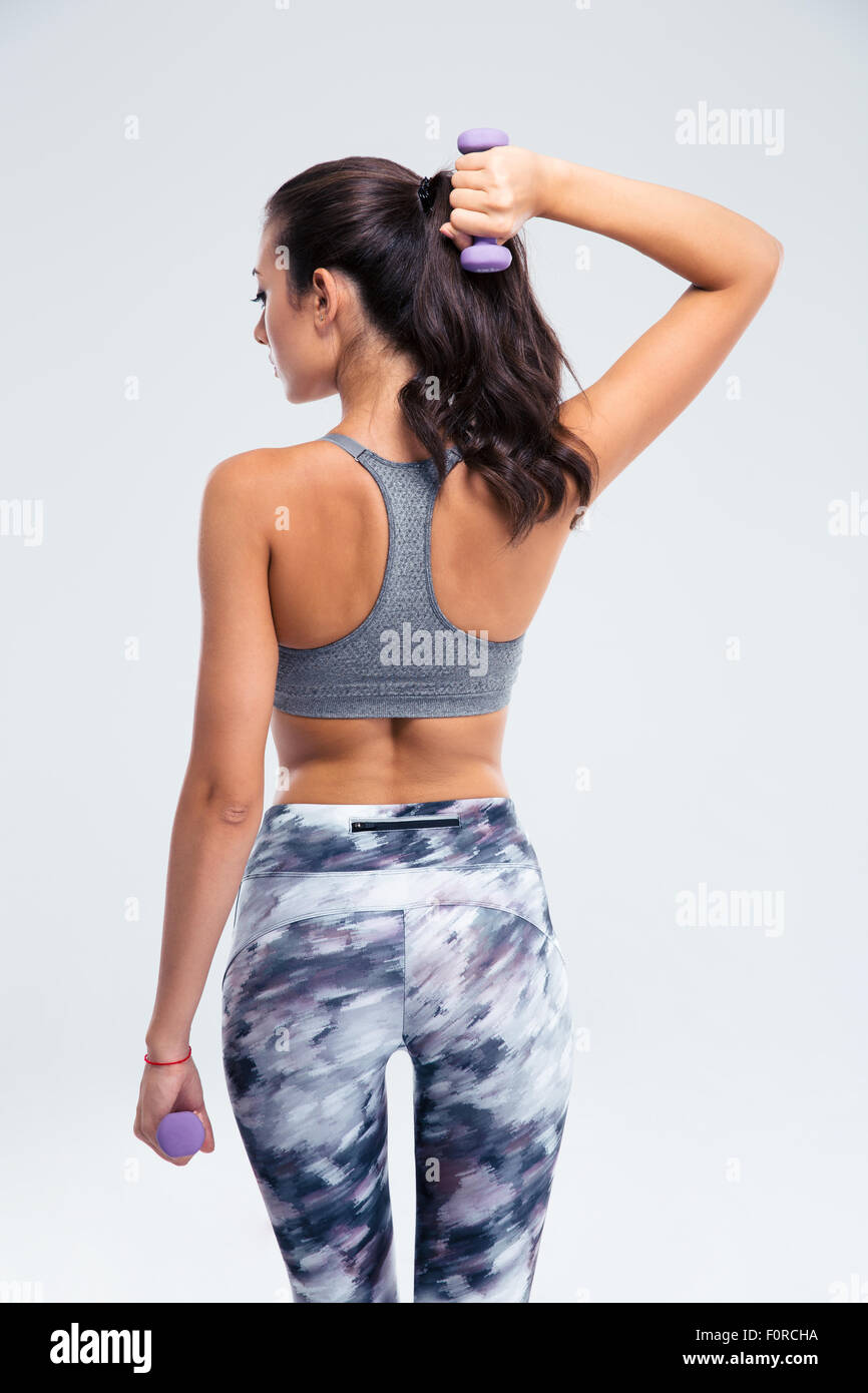 Back view portrait of a fitness woman working out with small dumbbells isolated on a white background Stock Photo