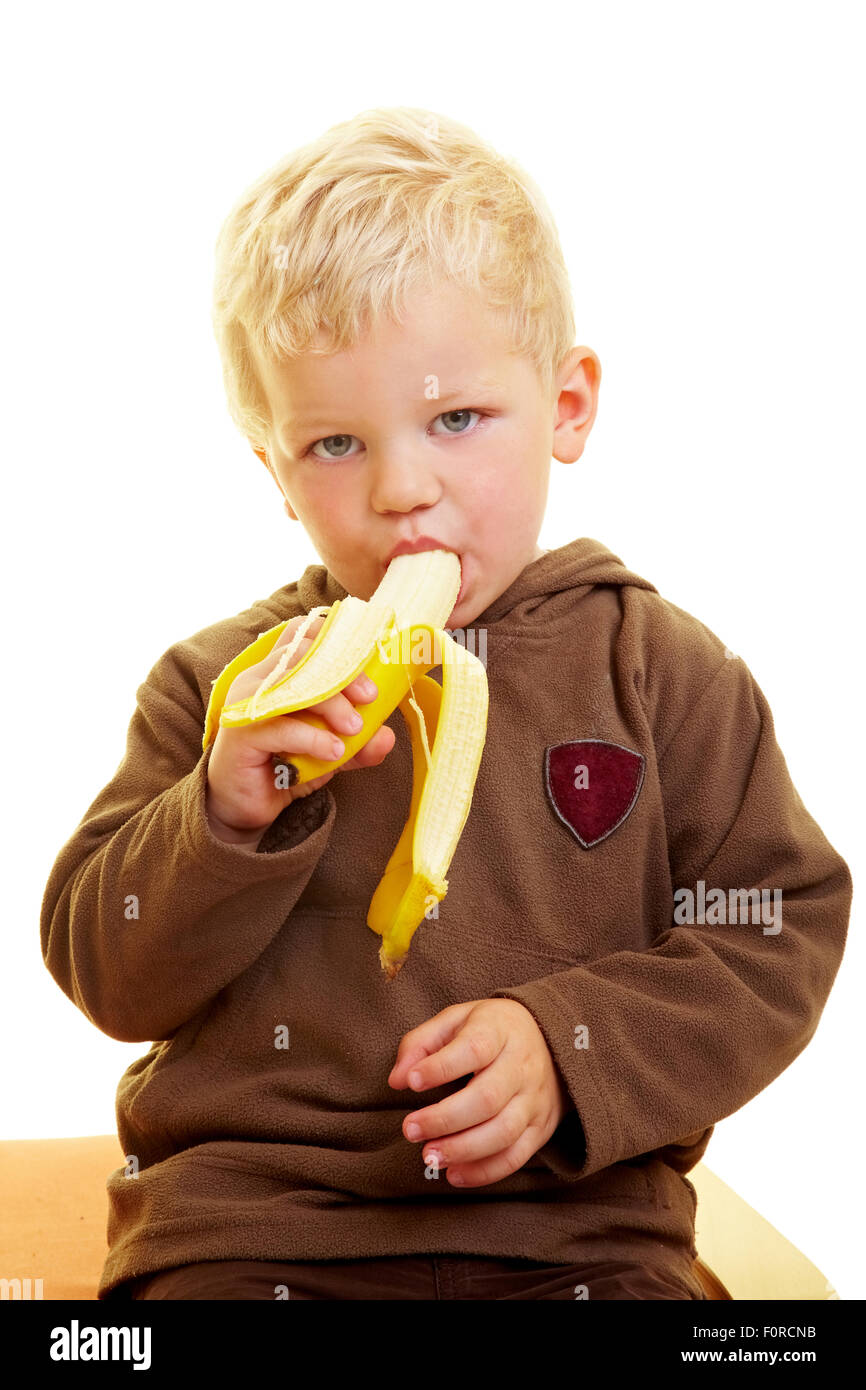 Young boy eats a banana Stock Photo - Alamy