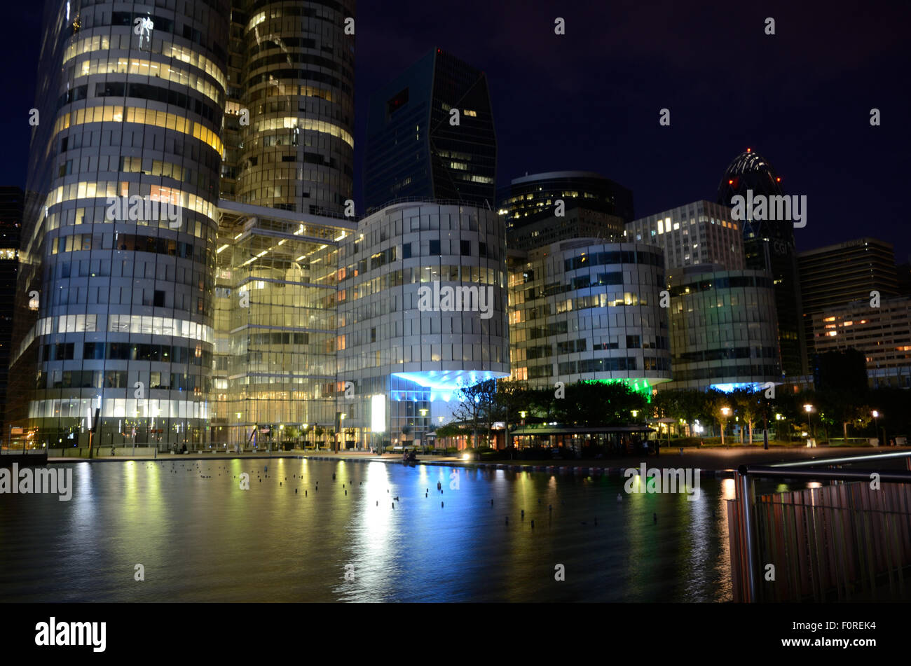 Office blocks at La Defense in Paris at night with lights reflecting in a pool infront. Stock Photo