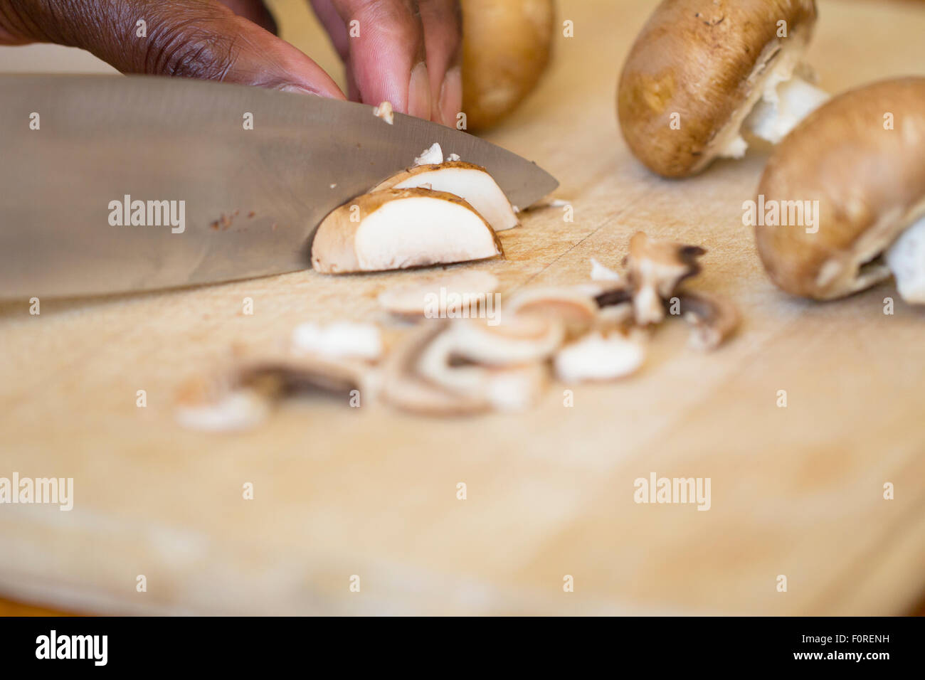 Black Man Chopping Mushrooms Stock Photo