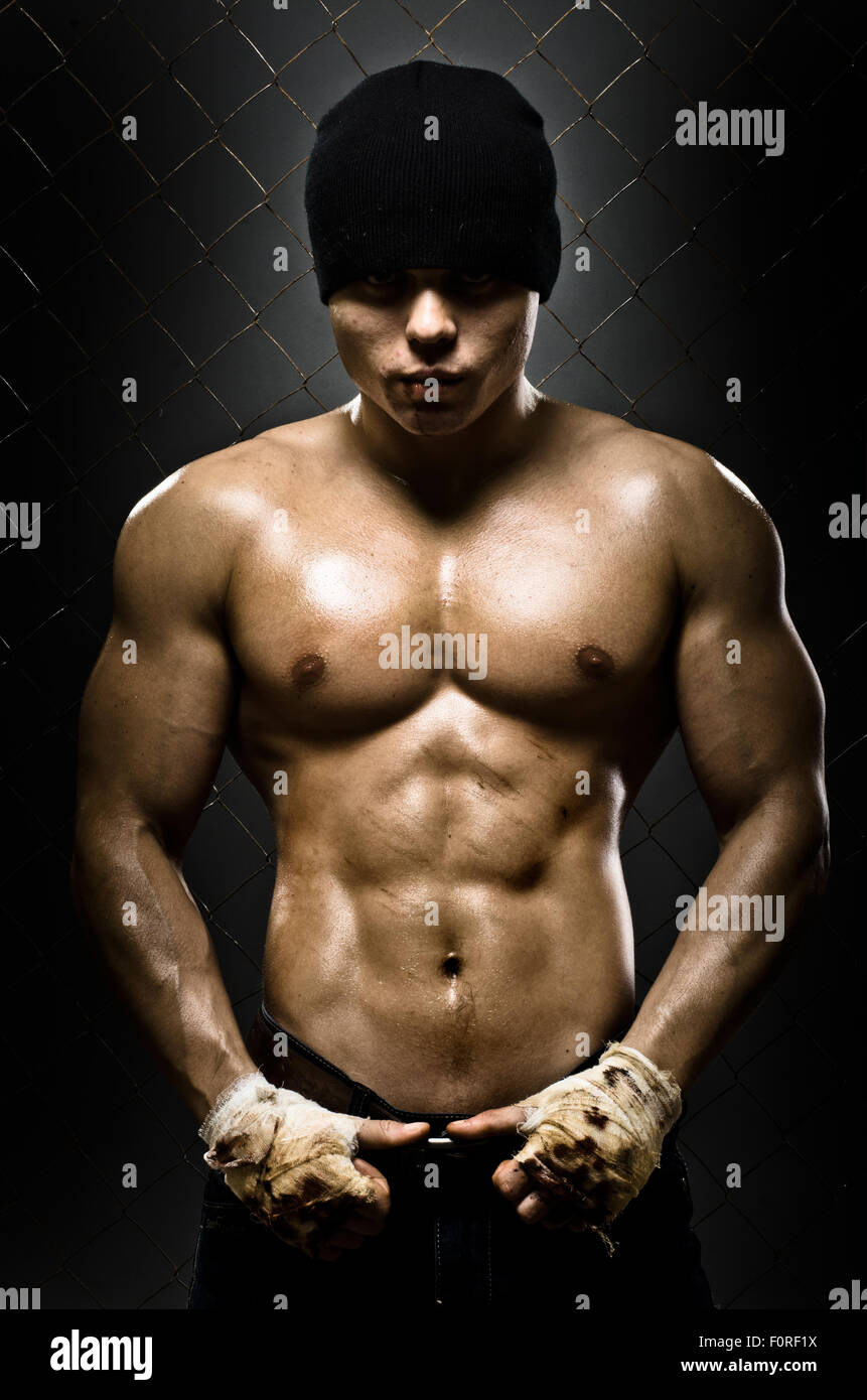 vertical photo  muscular young  guy street-fighter,  aggression look, hard light Stock Photo