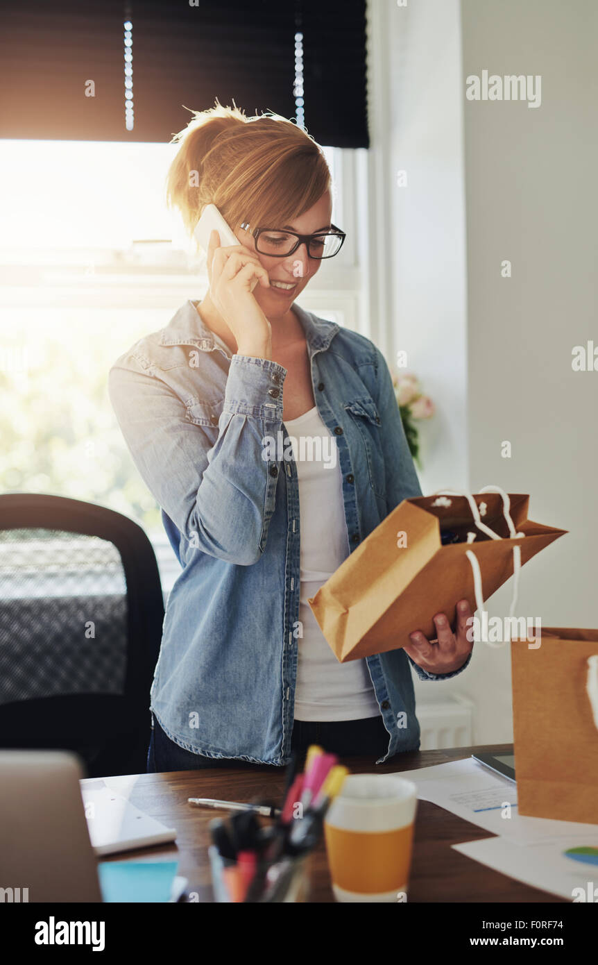 Smiling attractive young female entrepreneur standing in her home