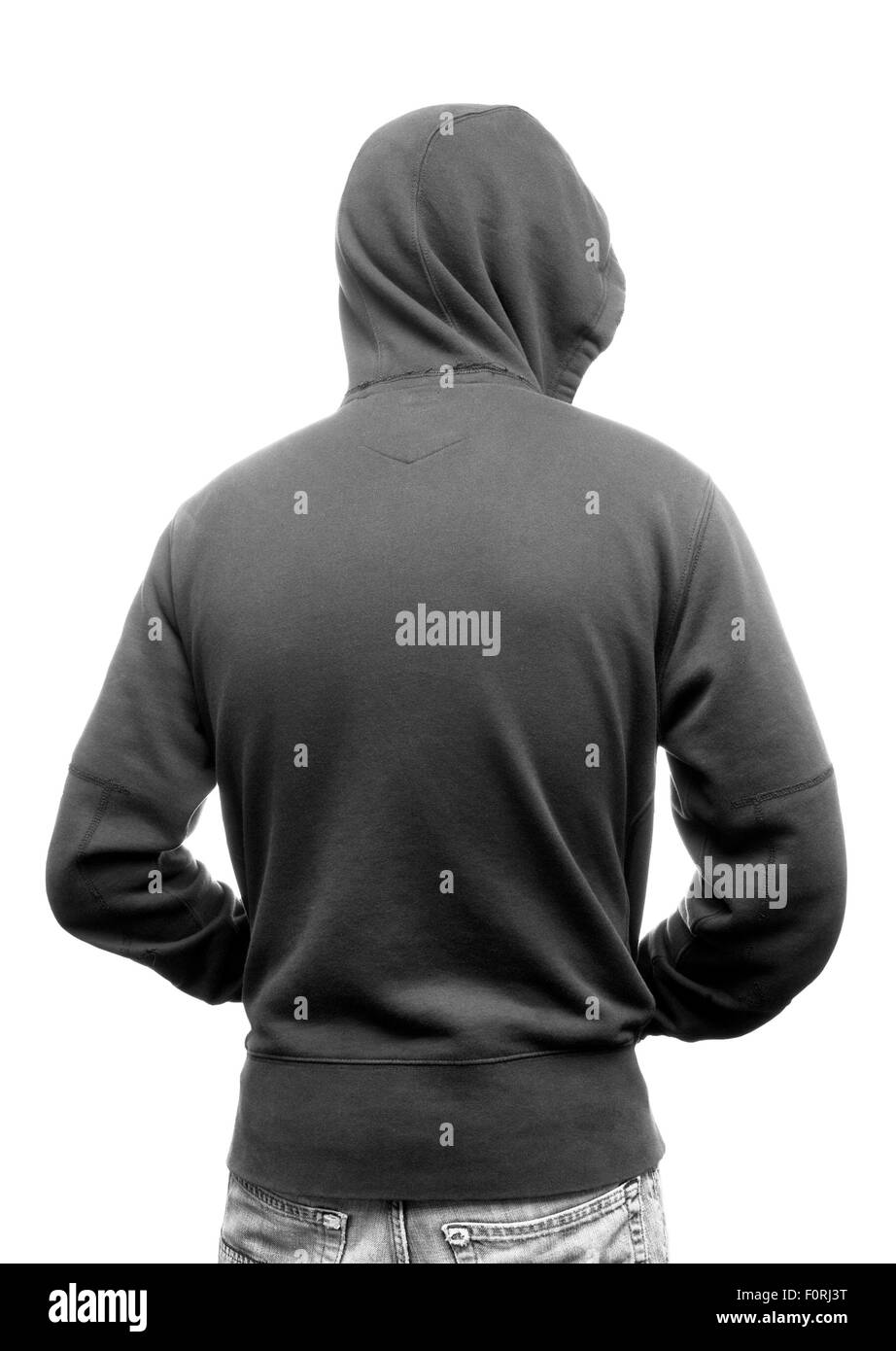 Youth in hooded top shot from behind, backlit in black and white. Stock Photo