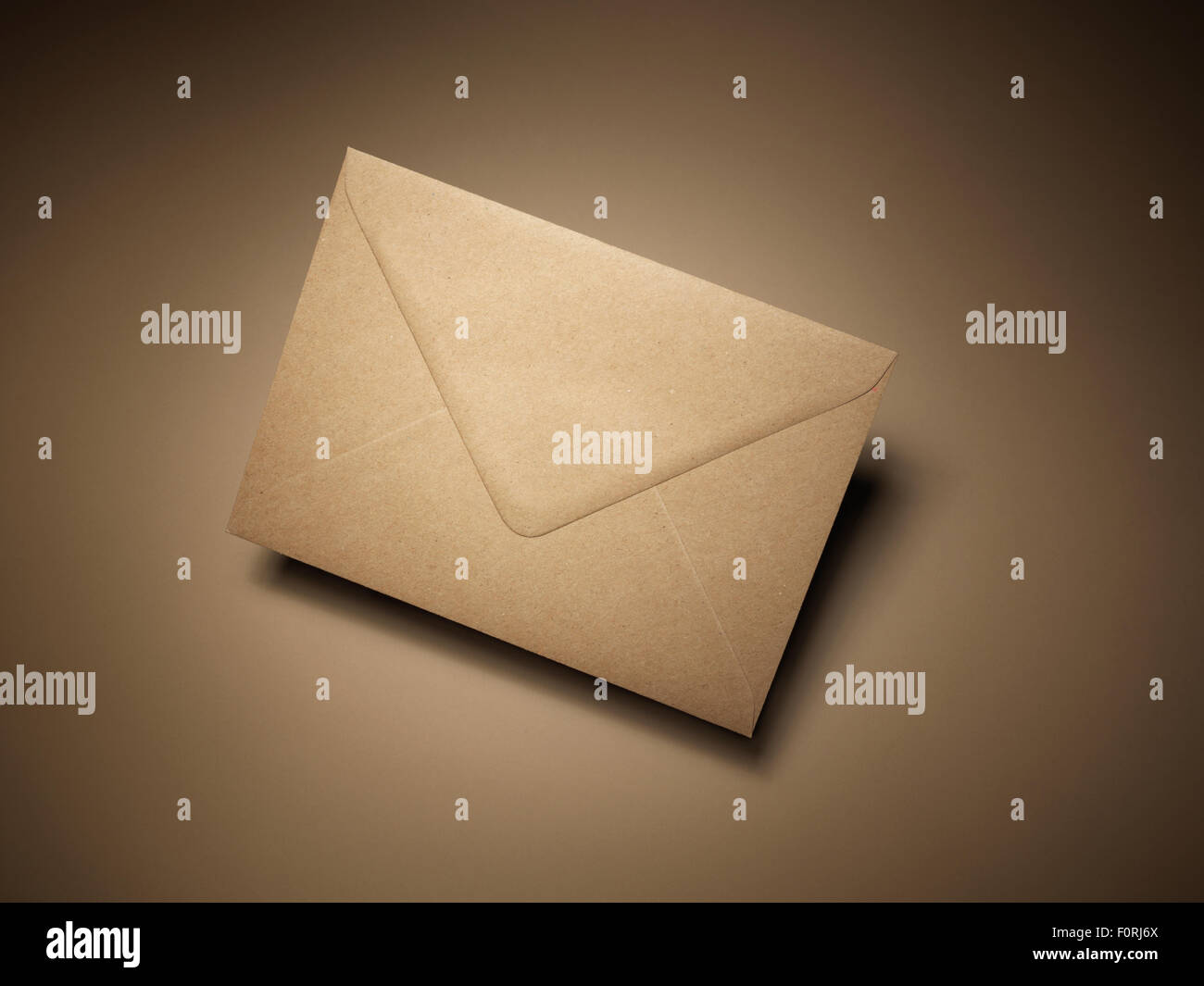 Shot of the front of a brown mail envelope suggesting communication. The image has copy space and a natural halo created by ligh Stock Photo