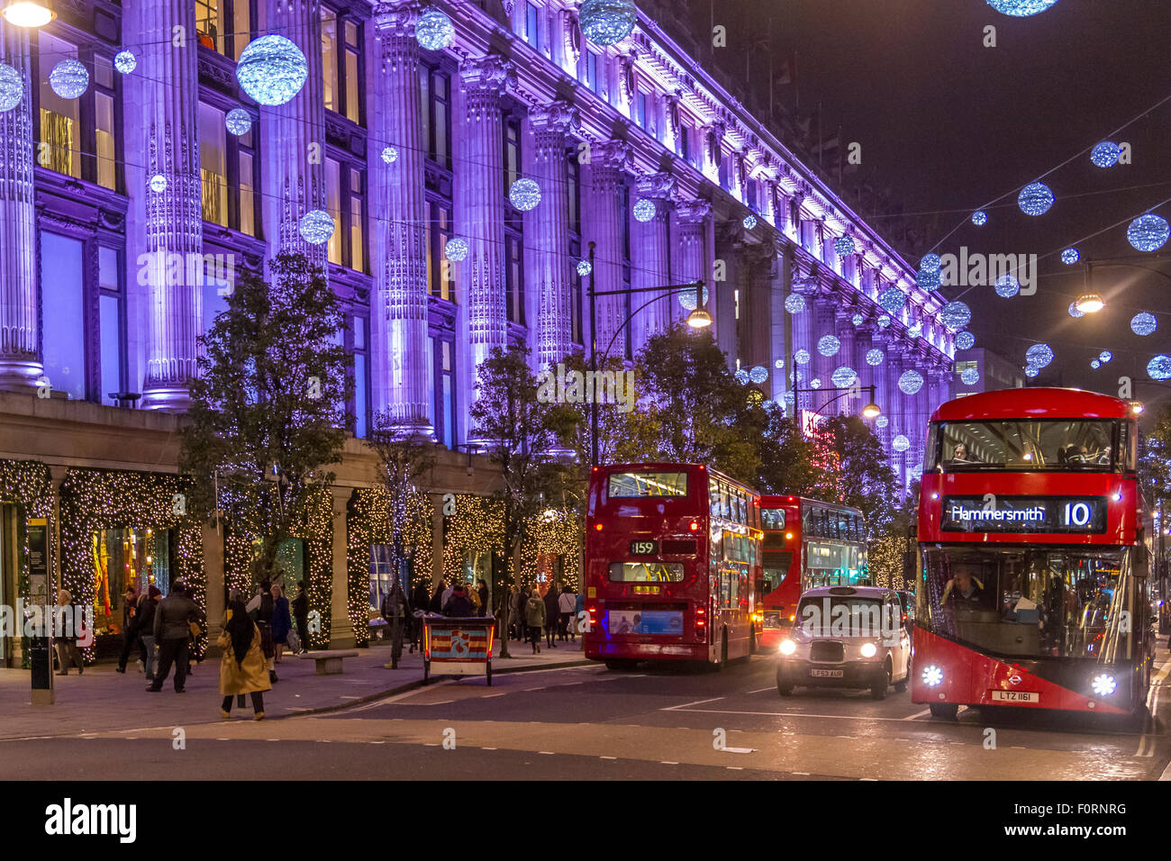 London Buses outside Selfridges on Oxford St filled with Christmas shoppers at Christmas Time with the Oxford St lights on display ,Oxford St ,London Stock Photo