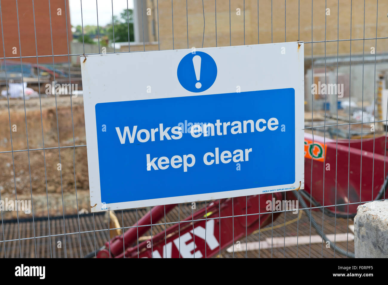 Works entrance keep clear sign on fence of a construction site Stock Photo