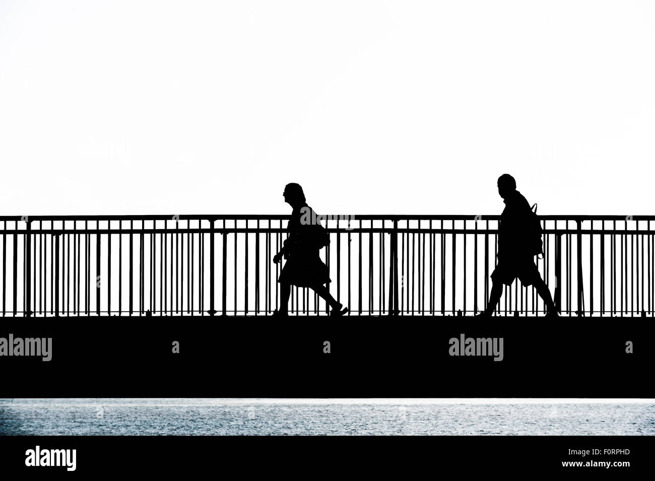 The silhouette of people walking across the Louisa Gap Bridge in ...