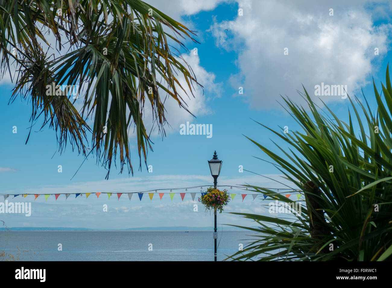 An image taken at Penarth seafront of a traditional street light, bunting, flowers and Mediterranean foliage. Stock Photo