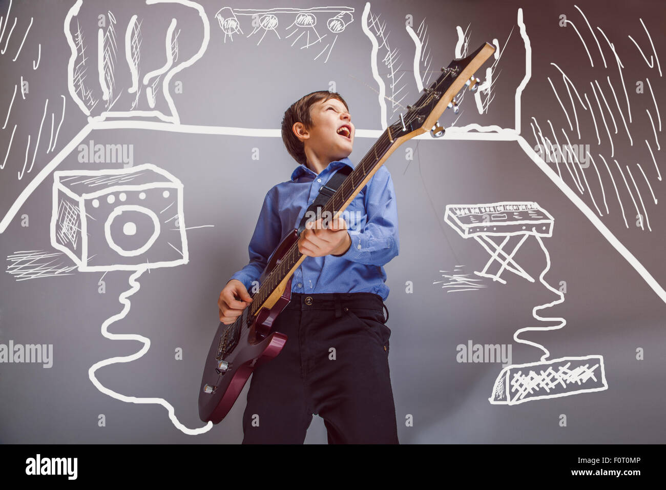 Teen boy playing guitar in the room are speakers synth rock conc Stock